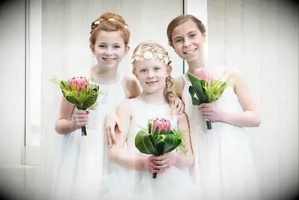 Flower girls holding protea single flower bouquets