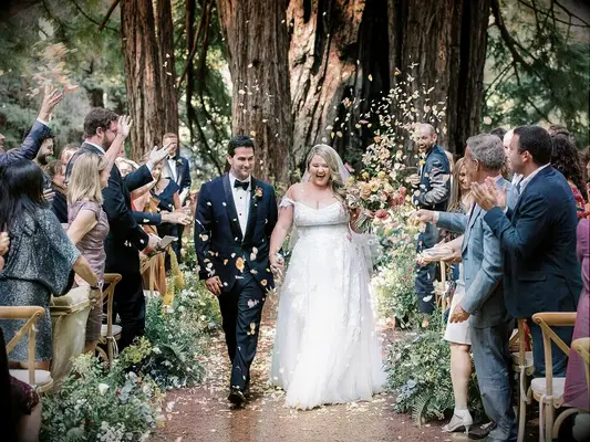 Bride and groom recessional with guests throwing leaves. 