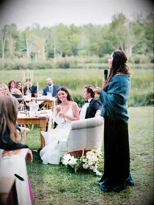 Maid of honor giving wedding speech outdoors