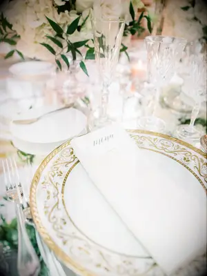 Antique gold and white table settings at elegant garden wedding
