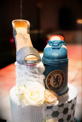 Wedding cake that is decorated for a soccer fan on one half. 