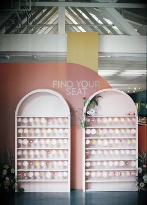 Pink and coral wedding escort display at boho wedding