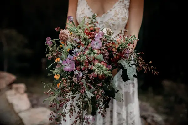 Purple and red wildflower bouquet at a boho wedding