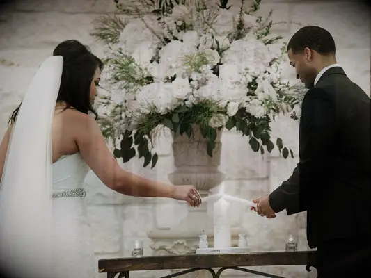 Bride and groom lighting candle during wedding unity ceremony