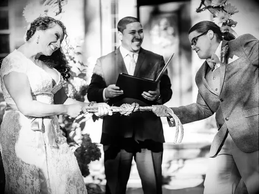 Couple tying eternity knot during wedding unity ceremony