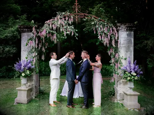 Grooms wearing traditional Greek Stefana crowns during wedding unity ceremony