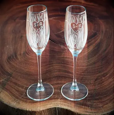 engraved wedding champagne flutes with tree trunk pattern and initials carved into a heart