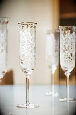 Vintage style champagne flutes with white decals for wedding from Anthropologie