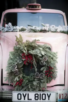 vintage pink cab decorated with greenery wreath on the hood