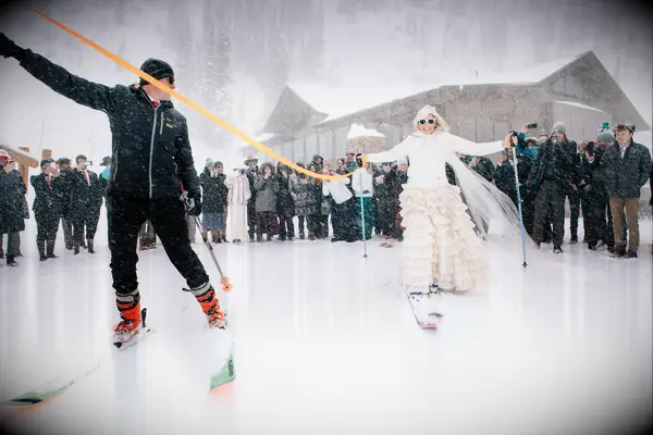 bride and groom leaving snowy wedding venue on skis