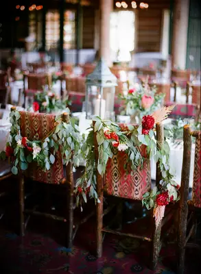 red patterned chairs at long banquet table decorated with eucalyptus garlands