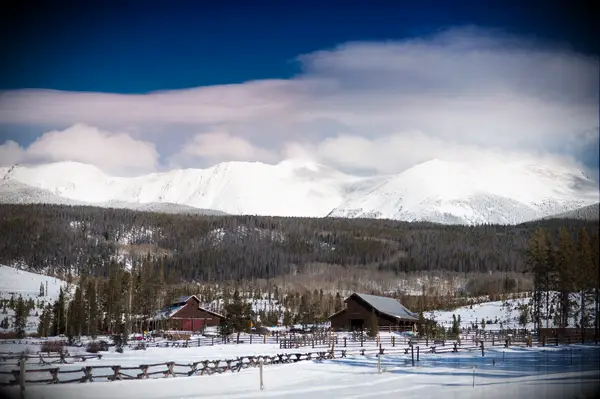 snowy mountain wedding venue with old barn and fence