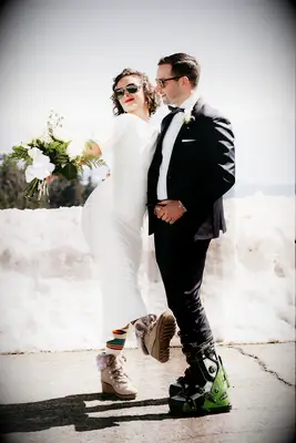 bride and groom wearing ski boots with their winter wedding attire