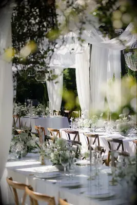 Outdoor greenery reception space with white drapery