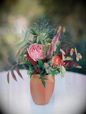 A petite flower arrangement with celosia in a clay vase