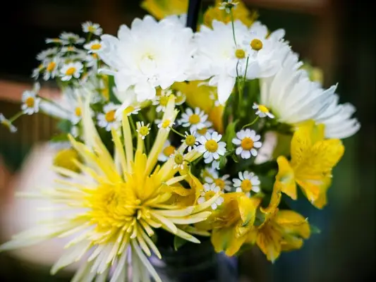 A wedding aisle flower arrangement with chamomile flowers and chrysanthemums