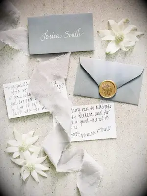 An invitation styled with flannel flower blooms