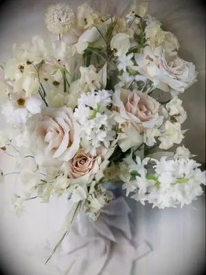 A wedding bouquet with beige roses and white hyacinth flowers