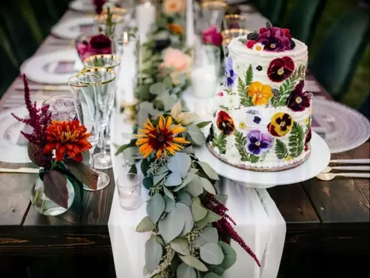 Farm table with rustic cake decorated with pansy blooms