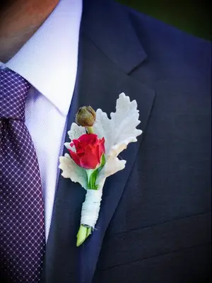 Dusty miller boutonniere on lapel of a navy suit