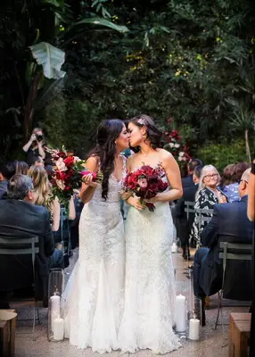 Two brides kissing at their wedding ceremony
