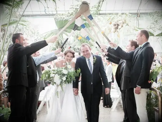 couple exiting Irish wedding under tunnel of hurley sticks