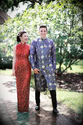 Couple in traditional Chinese wedding attire holding hands and walking