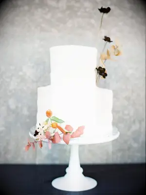 two-tier white cake with fresh cosmo flowers
