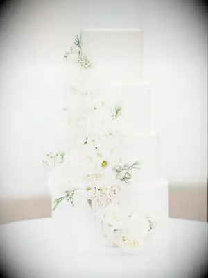 four-tier wedding cake decorated with white roses