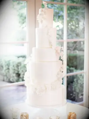 white wedding cake with white floral garland decoration