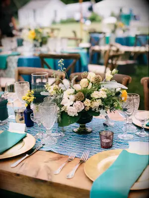 A turquoise, cream, and gold table setting.