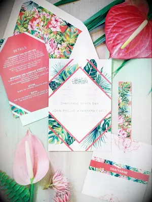 A coral-toned wedding invitation suite.