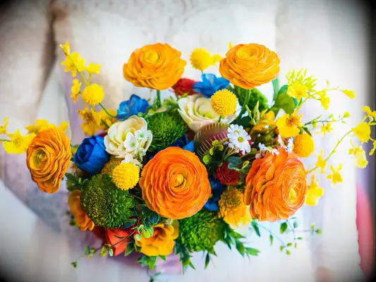 A vibrant orange, yellow, blue, and green bouquet.