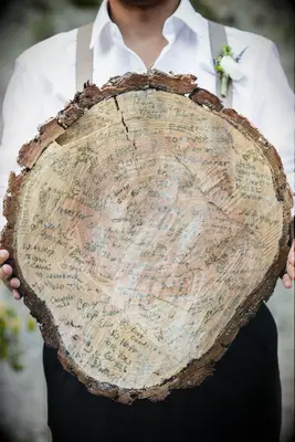 wedding guest book alternative with guest names written onto a sliced tree stump