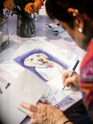 Guest writing on guest book sign with picture of dog