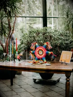 piñata guest book on wood farm table in greenhouse