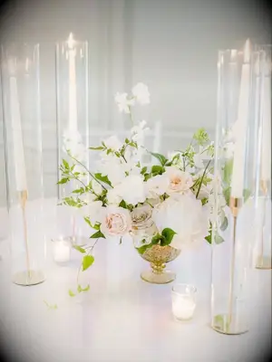 rose centerpiece in gold vase surrounded by taper candles