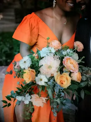 bride in orange dress holding orange rose bouquet