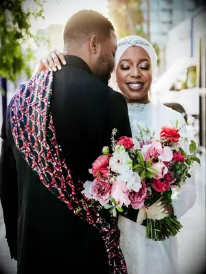 bride holding pink bouquet sharing embrace with groom