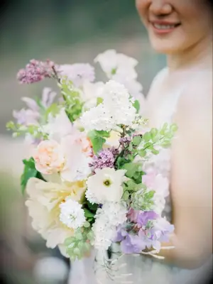 bride holding purple-and-white lilac bouquet
