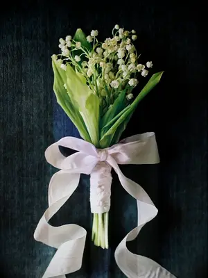 lily of the valley bouquet tied with white ribbon