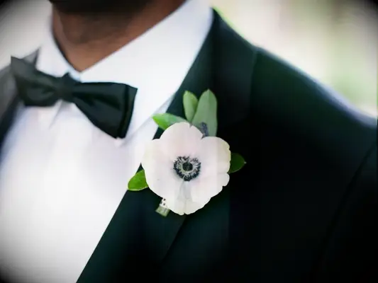 White anemone boutonniere on black tux lapel