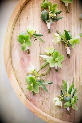 green hellebore wedding boutonnieres on a wooden tray