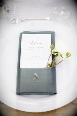 elegant wedding idea for spring simple white place setting with white rose tucked into folded gray napkin