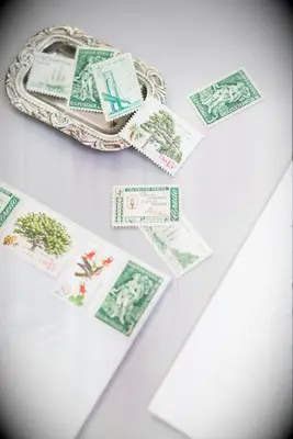 close up of vintage assorted green stamps on wedding invitation envelope