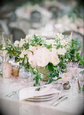 elegant spring wedding centerpiece with white garden roses and ivory flowers in small stone urn vase