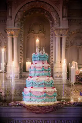 Fun and festive pastel four-tiered wedding cake with toppers
