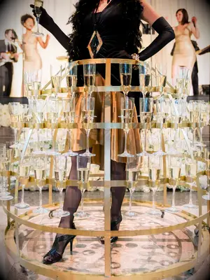 Server wearing metal hoop skirt filled with champagne flutes