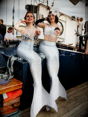 Performers dressed as mermaids on boat