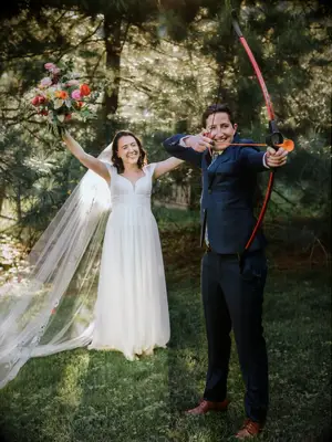 Couple doing archery during backyard wedding